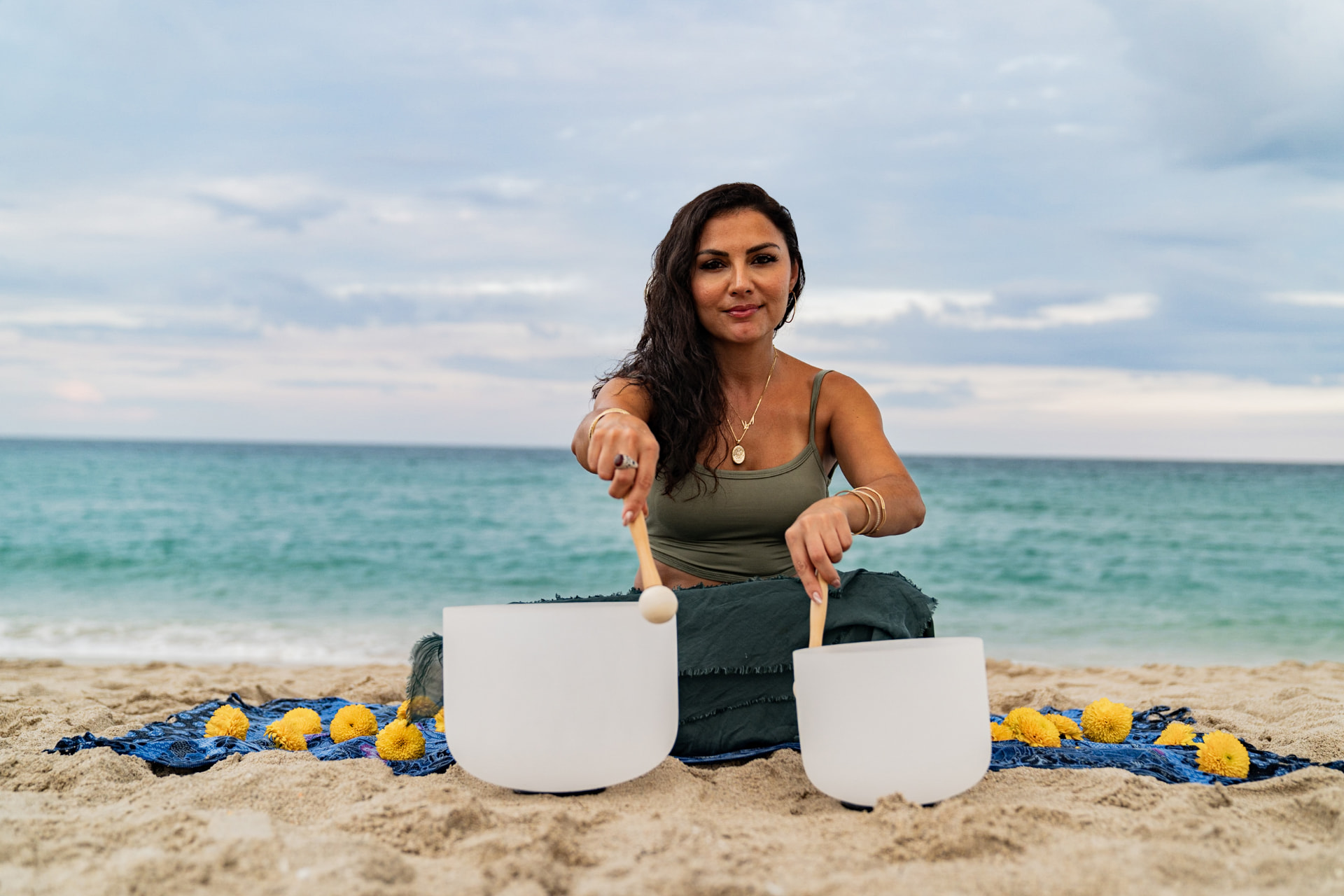 Elmira facing forward with two crystal bowls and marigolds on a beach blanket